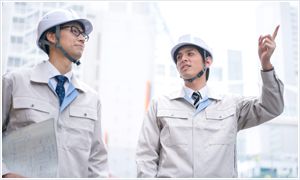指を指して話している男性2人